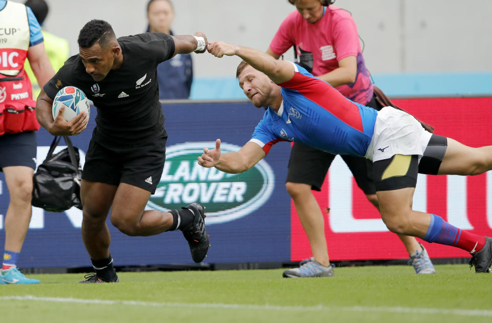 New Zealand's Sevu Reece runs past Namibia's Johan Tromp to score his team's first try during the Rugby World Cup Pool B game at Tokyo Stadium between New Zealand and Namibia in Tokyo, Japan, Sunday, Oct. 6, 2019. (AP Photo/Christophe Ena)