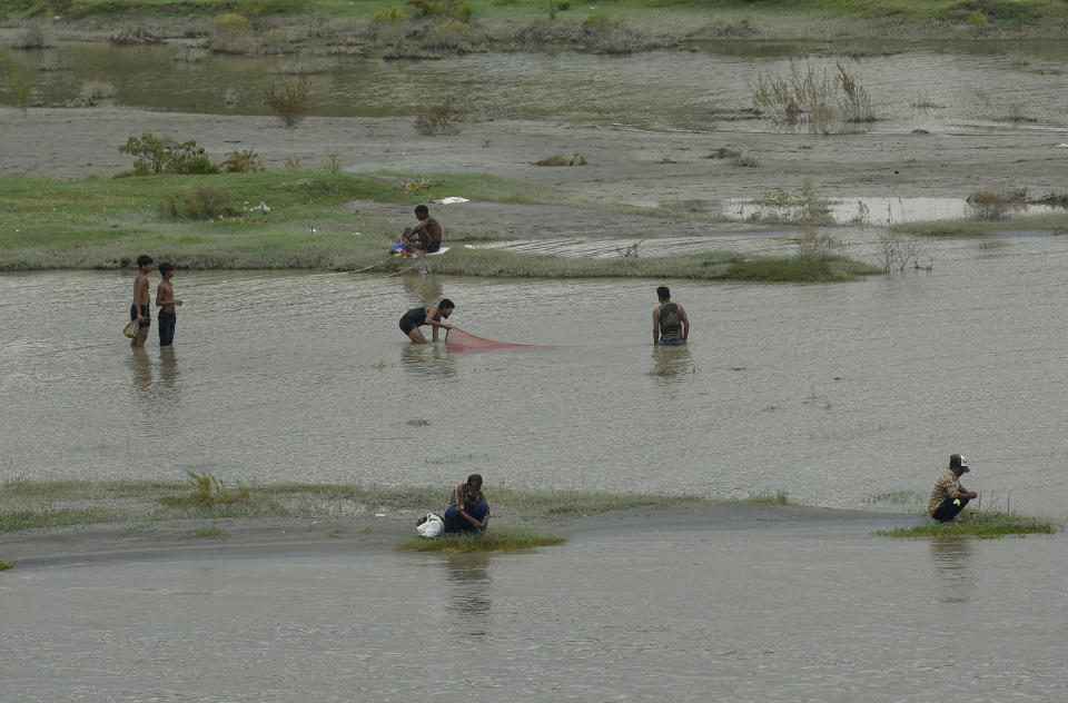 People fishing by the banks of the river Yamuna near Signature Bridge  on August 25, 2020 in New Delhi, India. The water level of the Yamuna river in Delhi was recorded at 204 metre at 10 am Tuesday, close to the warning level of 204.50 metre after water was released from the Hathnikund Barrage at Yamunanagar in Haryana. The Delhi government said, it is prepared to deal with any flood-like situation.  (Photo by Biplov Bhuyan/Hindustan Times via Getty Images)