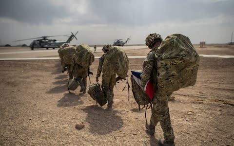 Wing Commander Matt Radnall, Officer Commanding 7 Force Protection Wing, carries a carefully folded Union Flag under his arm and back home to the UK as he walks out towards helicopter as the last British boots to leave Camp Bastion, Helmand Province, Afghanistan, as UK and Coalition forces carry out their Tactical Withdrawal finally leaving the base, handing it over to Afghan National Army - Credit:  Ben Birchall/PA