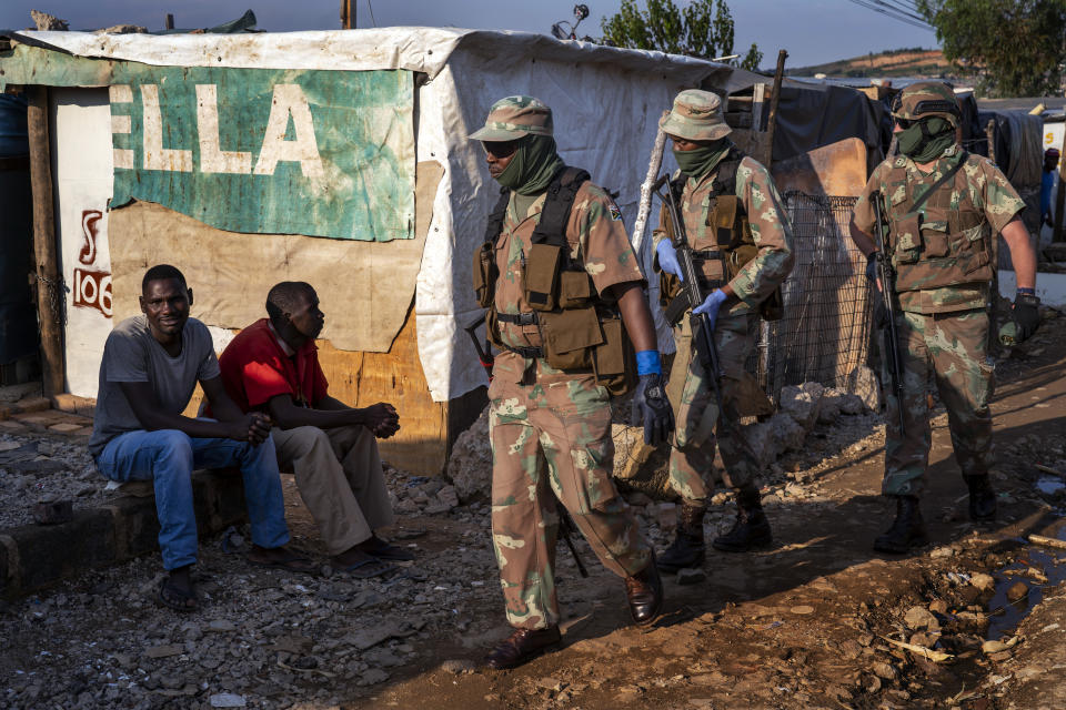 South African National Defense Forces patrol the Sjwetla informal settlement after pushing back residents into their homes, on the outskirts of the Alexandra township in Johannesburg, Monday, April 20, 2020. The residents were protesting the lack of food. Many have lost their income as South Africa is under a strict five-week lockdown in a effort to fight the coronavirus pandemic. (AP Photo/Jerome Delay)