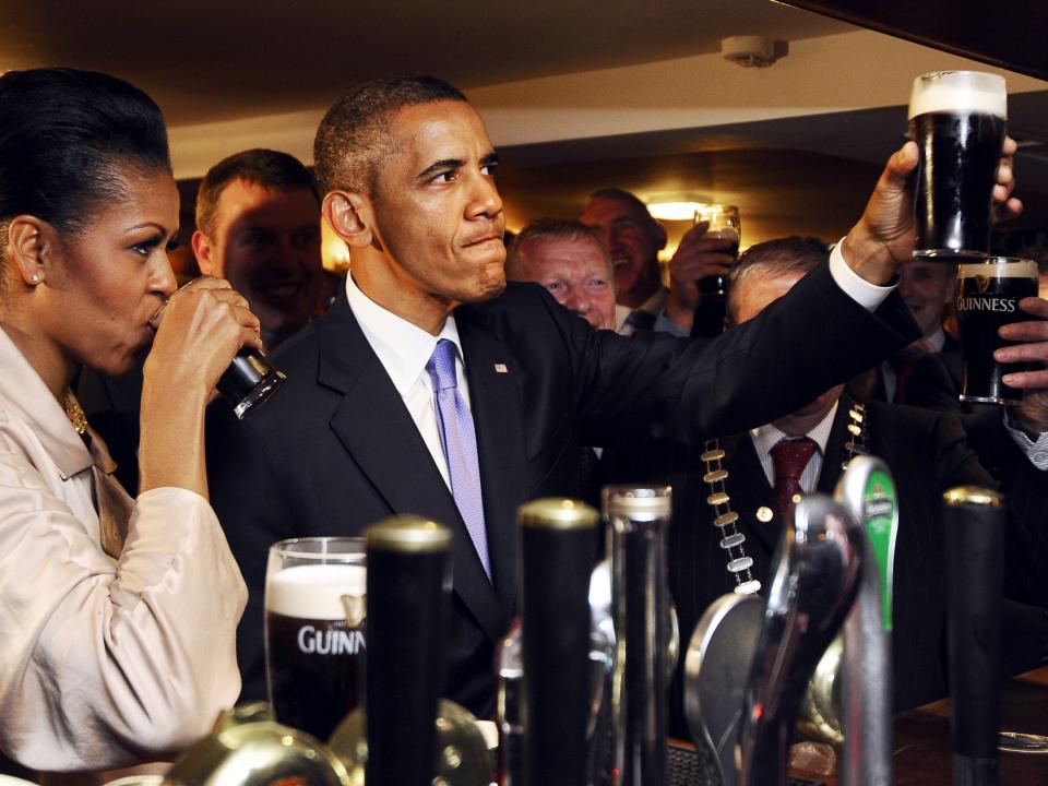 Barack and Michelle Obama drinking Guinness beer pints in an Irish pub.