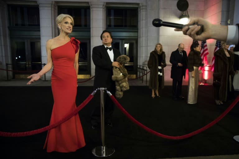 George Conway stands in the background as his wife Kellyanne Conway speaks to reporters at an event for President Donald Trump's 2017 inauguration