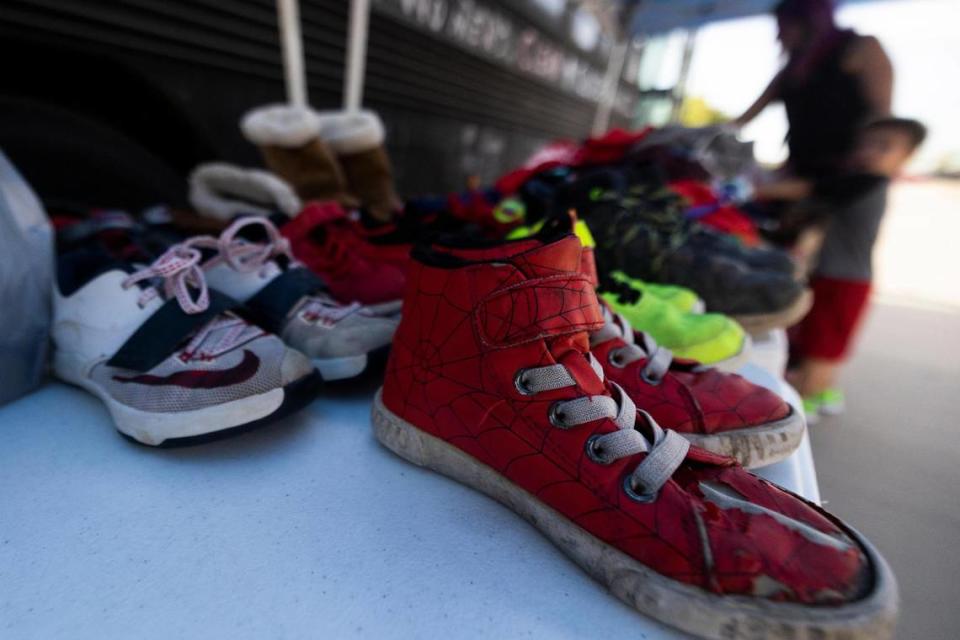 Children’s clothing and shoes are laid out for people to take during a CleanUP event Tuesday, Aug. 9, 2022, in Fort Worth. CleanUP hosts events throughout the area to offer free haircuts and clothing.