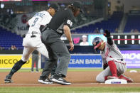 Washington Nationals' Cesar Hernandez, right, slides past Miami Marlins third baseman Erik Gonzalez (9) with a triple during the first inning of a baseball game, Wednesday, May 18, 2022, in Miami. (AP Photo/Lynne Sladky)
