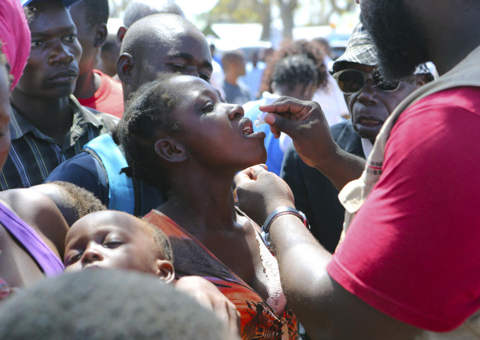 A woman receives an oral cholera vaccination at a camp for displaced survivors of cyclone Idai in Beira, Mozambique, Wednesday, April, 3, 2019. A cholera vaccination campaign is kicking off to reach nearly 900,000 cyclone survivors in Mozambique as officials rush to contain an outbreak of the disease. (AP Photo/Tsvangirayi Mukwazhi)