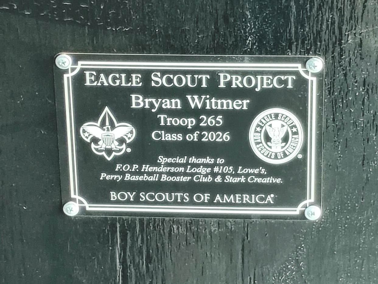A plaque commemorating the Eagle Scout project by Bryan Witmer that is affixed to the side of the dugout benches at the Perry varsity baseball field