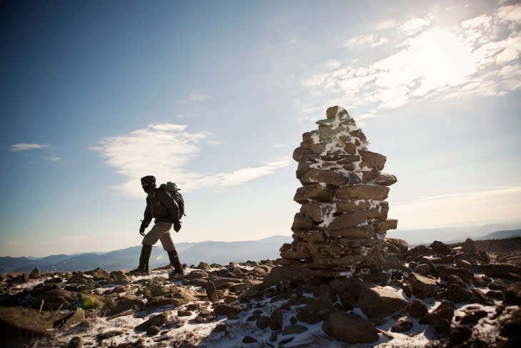 A mountaineer walks past a cairn on his way to the summit of Mount Moosilauke in the White Mountains of New Hampshire.