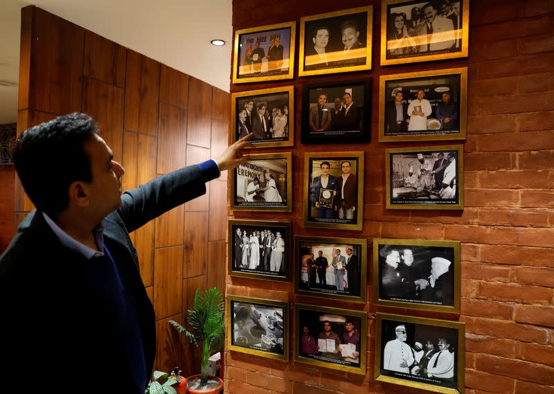 Moti Mahal Delux Managing Director Monish Gujral shows photographs of celebrities and politicians inside the restaurant in New Delhi