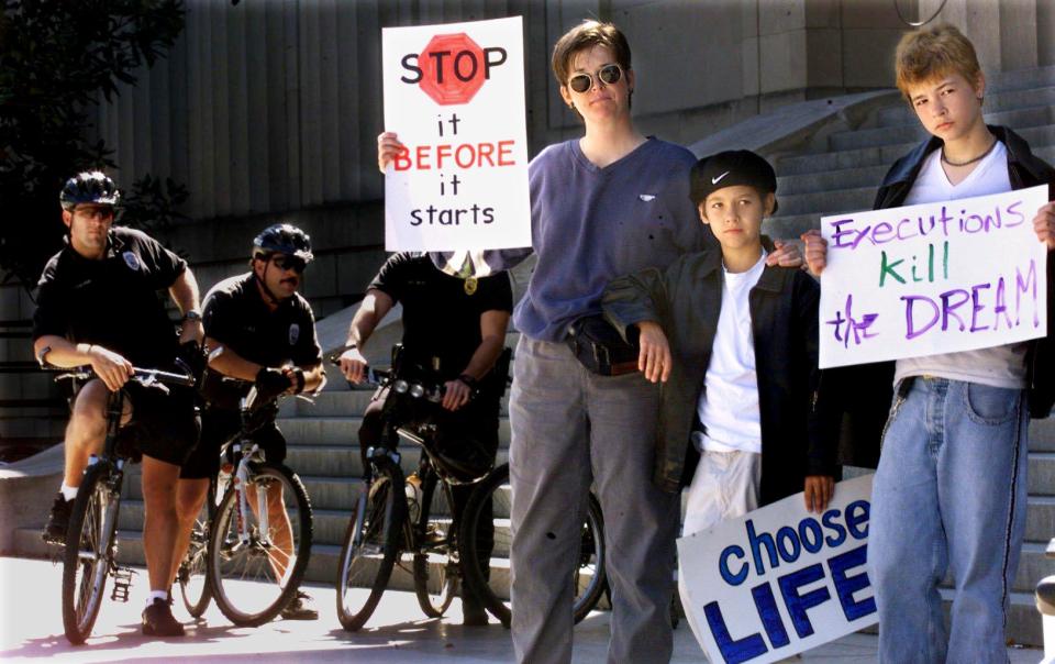 With Metro police watching nearby, the Rev. Jodie McCullah, left, and her sons, Spencer Hall and Arlo Hall to the rally at Legislative Plaza to speak out publicly against the death penalty Oct. 14, 1999.