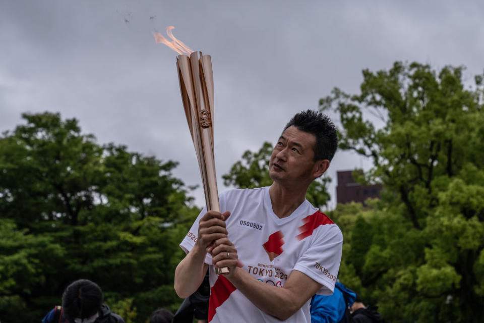 A Tokyo 2020 Olympics torch bearer pauses during a relay in the Hiroshima Peace Park in Hiroshima, Japan. 