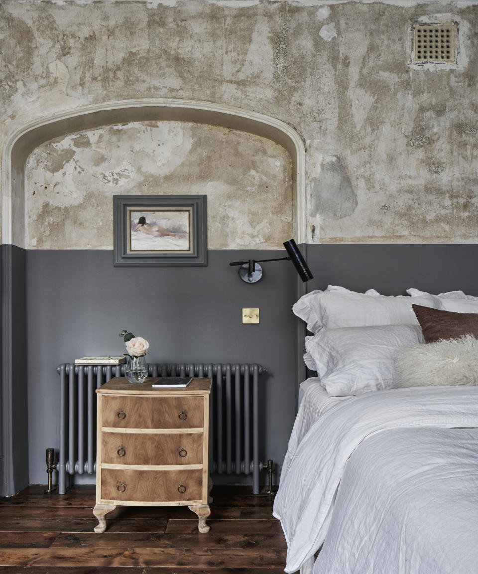 Raw plaster walls in a Georgian house modern bedroom with white linen