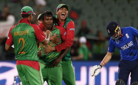 Bangladesh bowler Rubel Hossain (2nd L), team captain Masrafe bin Mortaza and Taskin Ahmed (on Hossain's back) react after England captain Eoin Morgan was caught out for a duck during their Cricket World Cup match in Adelaide, March 9, 2015. At right is England batsman Joe Root. REUTERS/David Gray