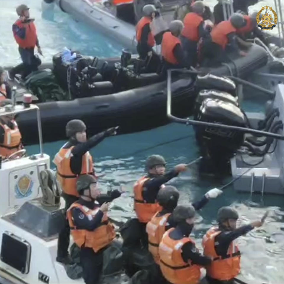 In this handout photo provided by Armed Forces of the Philippines, Chinese Coast Guard hold knives and machetes as they approach Philippine troops on a resupply mission in the Second Thomas Shoal at the disputed South China Sea on June 17, 2024. The Philippine military chief demanded Wednesday that China return several rifles and equipment seized by the Chinese coast guard in a disputed shoal and pay for damage in an assault he likened to an act of piracy in the South China Sea. (Armed Forces of the Philippines via AP)