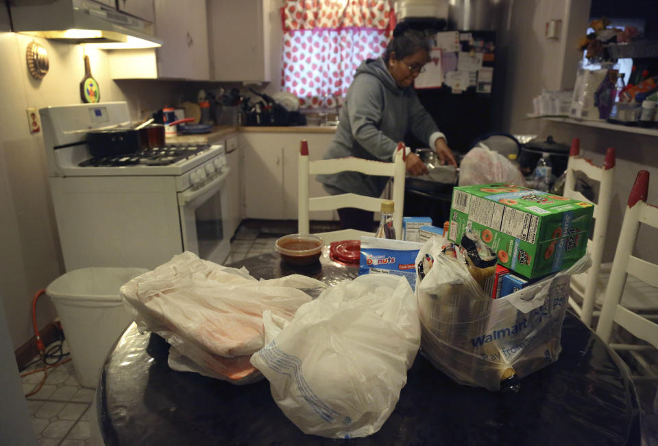 Bags of food from a local church pantry sit on the kitchen table in the home of Silvia De Leon in Noel, Mo., Saturday, Nov. 21, 2020. After losing her sense of taste, the Tyson Foods employee realized she had contracted the coronavirus and was out of work for several weeks. She has utilized the food pantry every Saturday for the past five months as she and her retired husband pay off coronavirus related medical bills. "If it weren't for this, I don't know what I'd do," said De Leon. (AP Photo/Jessie Wardarski)