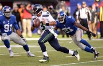 Dec 15, 2013; East Rutherford, NJ, USA; Seattle Seahawks quarterback Russell Wilson (3) gets away from New York Giants free safety Ryan Mundy (21) during the first half at MetLife Stadium. Mandatory Credit: Joe Camporeale-USA TODAY Sports
