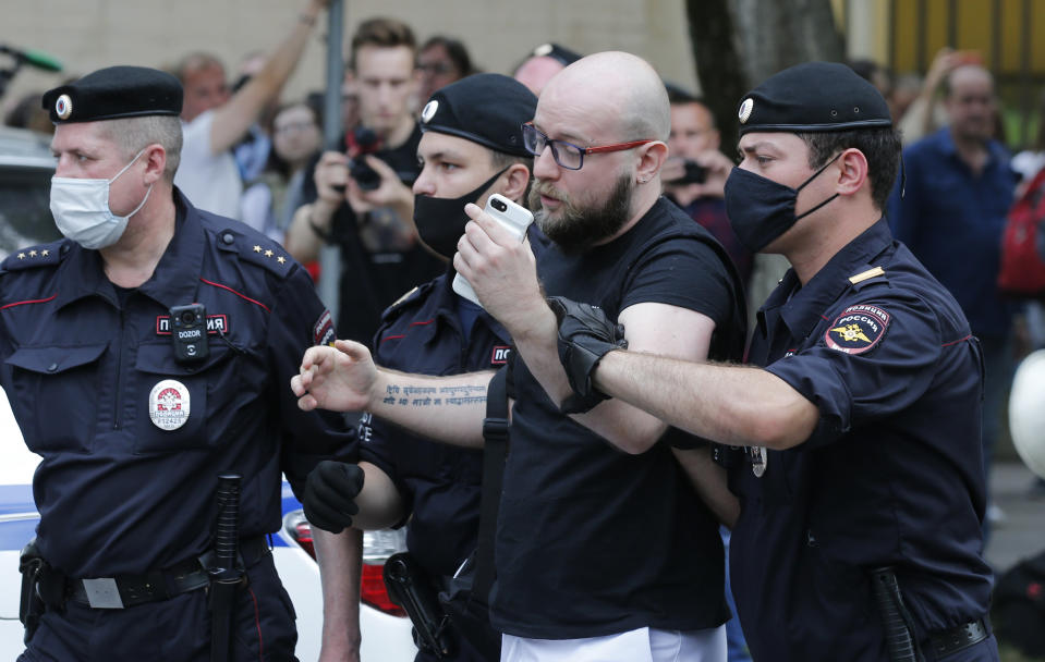 Police officers detain Alexander Chernykh, Kommersant newspaper journalist, during a rally to support Ivan Safronov near the Lefortovo prison in Moscow, Russia, Monday, July 13, 2020. Safronov, an ex-journalist who worked as an adviser to the director of Russia's state space corporation has been arrested and jailed on charges of passing military secrets to Czech intelligence. Ivan Safronov wrote about military and security issues before becoming an adviser to the head of Roscosmos. (AP Photo/Alexander Zemlianichenko)