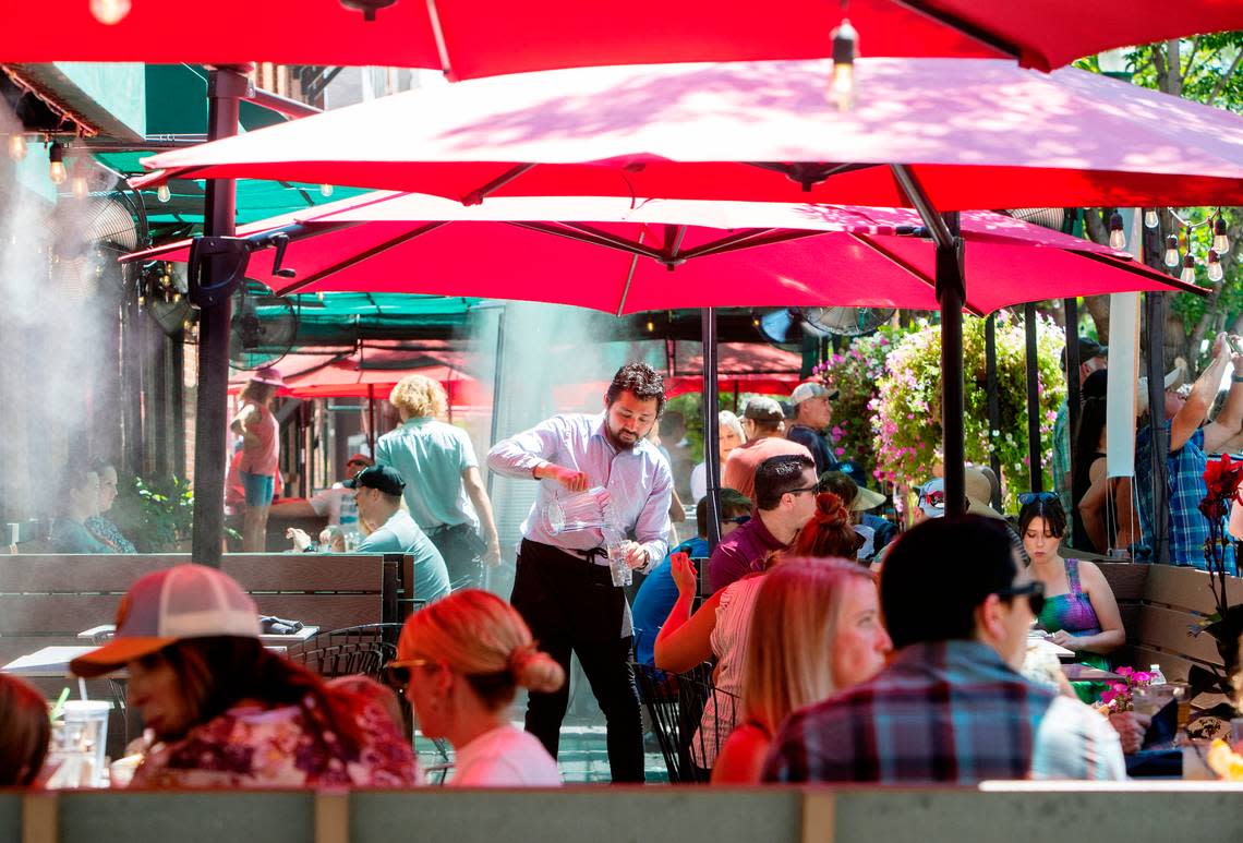 Waiter David Kan serves cold water to restaurant patrons on the patio of Bardenay in the Basque Block of downtown Boise on July 30, 2022. Temperatures above 100 degrees are expected over the weekend.