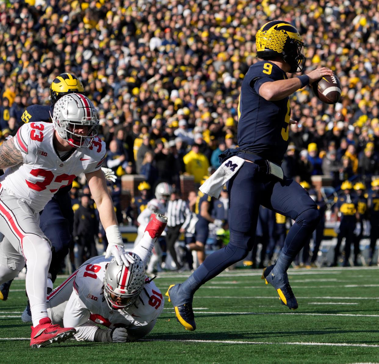 Nov. 25, 2023; Ann Arbor, Mi., USA;
Michigan Wolverines quarterback J.J. McCarthy (9) is pursued by Ohio State Buckeyes defensive end Jack Sawyer (33) and Ohio State Buckeyes defensive tackle Tyleik Williams (91) during the first half of Saturday's NCAA Division I football game at Michigan Stadium.