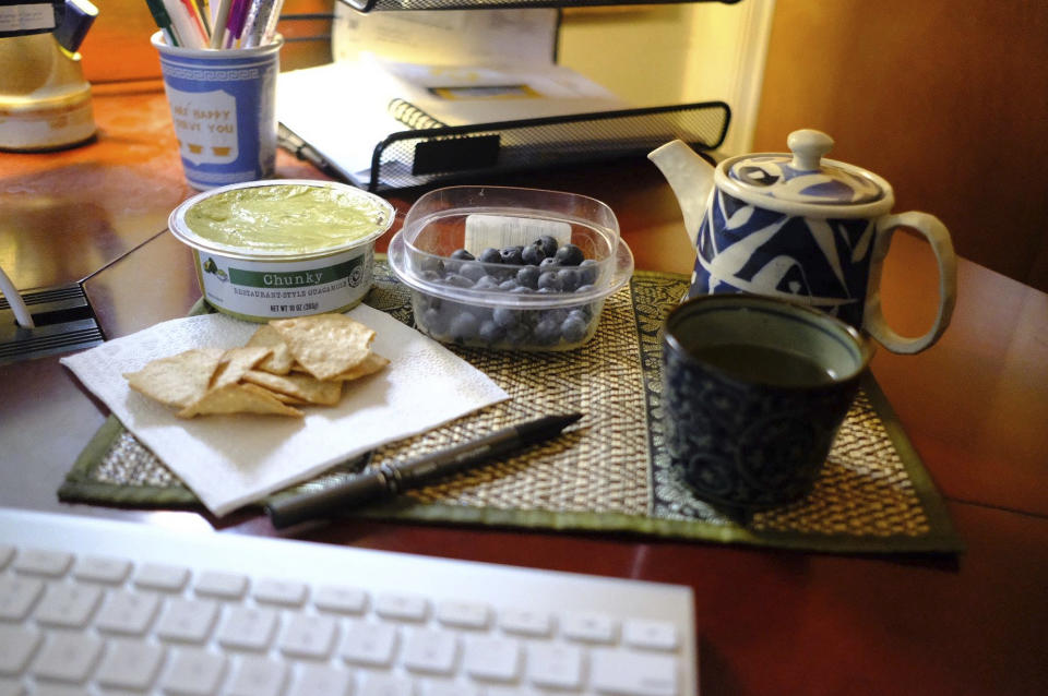 This Jan. 17, 2020 image shows a display of guacamole and chips and blueberries in Allison Park, Pa. To eat healthier in the new year, try making small and measurable changes, like bringing a healthy and appealing snack to work. (Ted Anthony via AP)