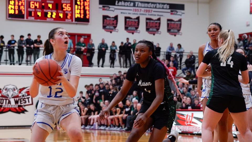 Springboro's Bryn Martin (12) drives past Mason's Madison Parrish (4) for a layup in a Division I regional semifinal game on March 6, 2024 at Lakota West High School in West Chester, Oh.