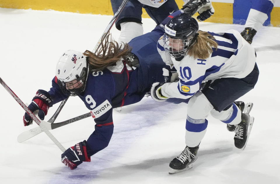United States' Kirsten Simms (9) is tripped up by Finland's Elisa Holopainen (10) during the first period in the semifinals of the IIHF women's world hockey championships Saturday, April 13, 2024, in Utica, N.Y. (Christinne Muschi/The Canadian Press via AP)