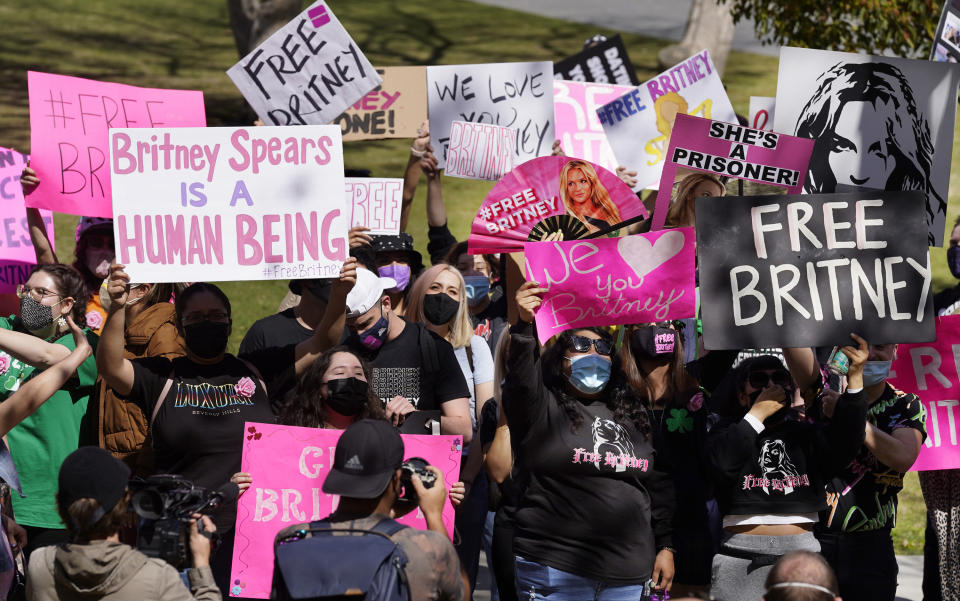 FILE - In this March 17, 2021 file photo Britney Spears fans hold signs outside a court hearing concerning the pop singer's conservatorship at the Stanley Mosk Courthouse, in Los Angeles. Spears' fight to end the conservatorship that controlled vast aspects of her life is putting the spotlight on ongoing efforts in U.S. states to reform laws that advocates say too often harm the very people they were meant to protect. (AP Photo/Chris Pizzello, File)