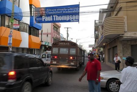 Residents walk along a downtown street in Belize City where campaign banners have been placed ahead of Wednesday's election, November 4, 2015. REUTERS/David Alire