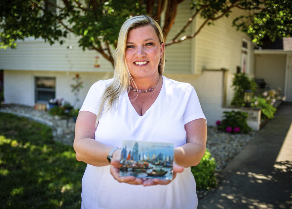 Kim Draper received a postcard at her home in Springfield on July 8, 2019 that was postmarked and sent from Hong Kong exactly 26 years ago on July 8, 1993 to a previous family that lived at her address. Draper is trying to track down the family that the postcard was sent to, which was addressed to Leena and Muhammad Ali Kizilbash and is signed "See you guys soon. Your Dad." (Justin L. Fowler/The State Journal-Register via AP)