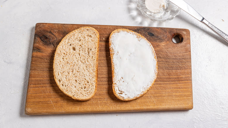 Two slices of bread, one with goat cheese on it