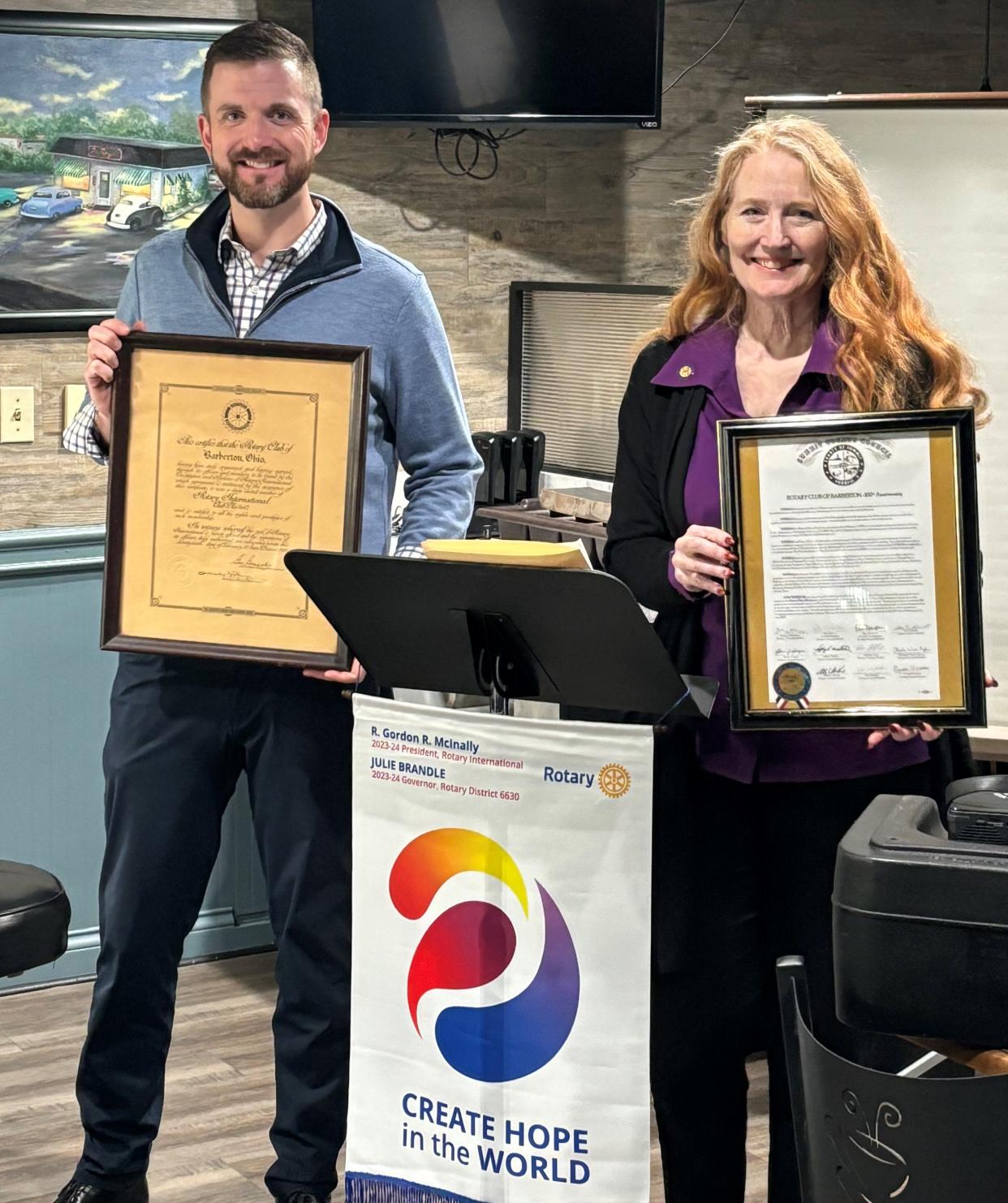 Summit County Councilwoman Bethany McKenney, right, displays a commendation for the Rotary Club of Barberton for 100 years of service.