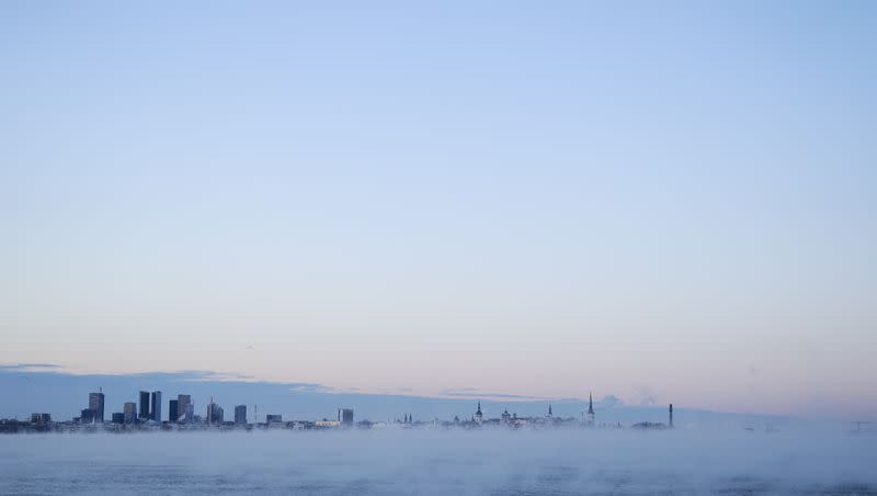 The moon is seen over the city as fog covers the Baltic sea in Tallinn, Estonia, Thursday, Jan. 4, 2024.