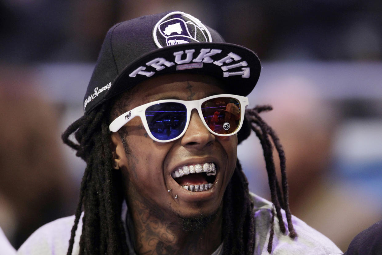 Rapper Lil Wayne watches the first half of the NBA All-Star basketball game, Sunday, Feb. 26, 2012, in Orlando, Fla. (AP Photo/Chris O'Meara)