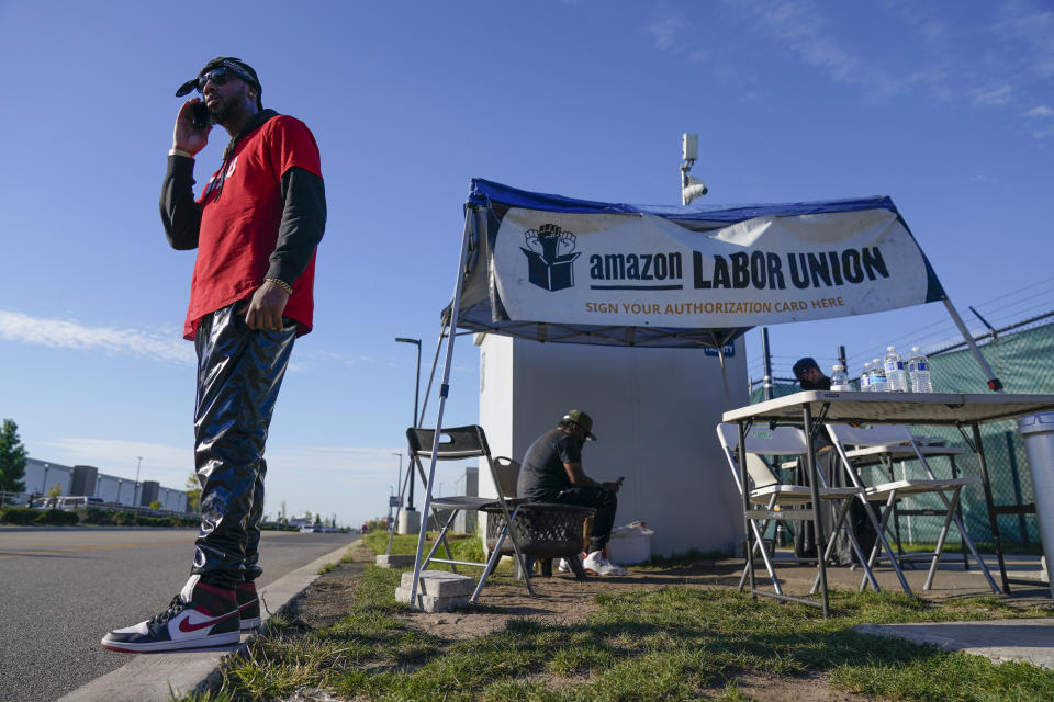 Chris Smalls, president of the Amazon Labor Union, talks on his phone across the street from an Amazon distribution center in the Staten Island borough of New York, Thursday, Oct. 21, 2021. A bid to unionize Amazon workers at the distribution center in New York City neared an important milestone, as organizers prepared to deliver hundreds of signatures to the National Labor Relations Board as soon as Monday for authorization to hold a vote. (AP Photo/Seth Wenig)