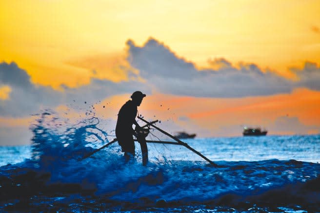 天色微亮，台東縣卑南溪出海口，民眾冒險搏浪撈魚苗。（莊哲權攝）