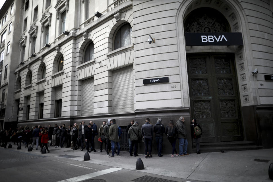 Argentines wait in line for BBVA bank to open in Buenos Aires, Argentina, Monday, Sept. 2, 2019. Some Argentines withdrew their savings from banks this past week amid fears of a default. (AP Photo/Natacha Pisarenko)