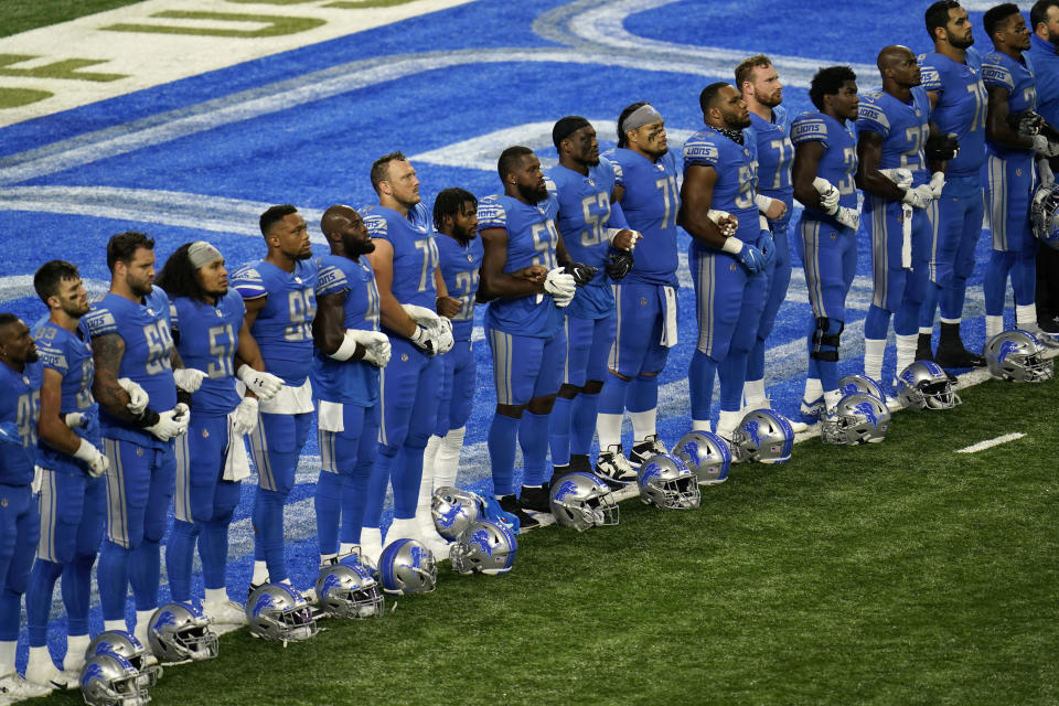 Detroit Lions players stand arm in arm during a social justice video before an NFL football game against the Chicago Bears in Detroit, Sunday, Sept. 13, 2020. (AP Photo/Paul Sancya)