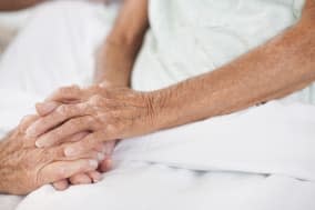 Husband comforting wife in hospital bed