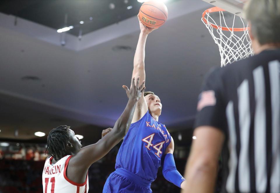 Kansas Jayhawks forward Mitch Lightfoot goes up for a dunk Tuesday as Oklahoma Sooners forward Akol Mawein defends during the first half at Lloyd Noble Center.