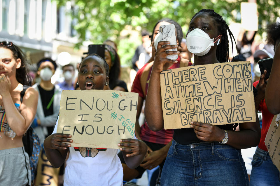 Protesters in Manchester hold placards.