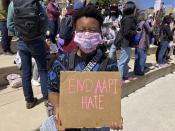 CORRECTS REFERENCE IN THIRD SENTENCE TO THEY STED OF SHE Camden Hunt poses for a picture at a rally on Saturday, March 20, 2021, across from the Georgia state Capitol in Atlanta to demand justice for the victims of shootings at massage businesses days earlier. A 21-year-old white man is accused of killing eight people, six of them women of Asian descent, at three Atlanta-area massage businesses Tuesday. Hunt said they came out to the rally Saturday to “show Black and Asian solidarity.” (AP Photo/Kate Brumback)