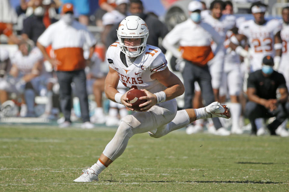 Texas quarterback Sam Ehlinger scrambles during the second half of the team's NCAA college football game against Oklahoma in Dallas, Saturday, Oct. 10, 2020. Oklahoma won 53-45 in four overtimes.(AP Photo/Michael Ainsworth)