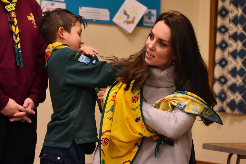 A cub scout uses a neckerchief to show Britain's Catherine, Duchess of Cambridge, how to support a broken arm, during a Cub Scout Pack meeting with cubs from the Kings Lynn District, in Kings Lynn, eastern England, on Dec.&nbsp;14, 2016.