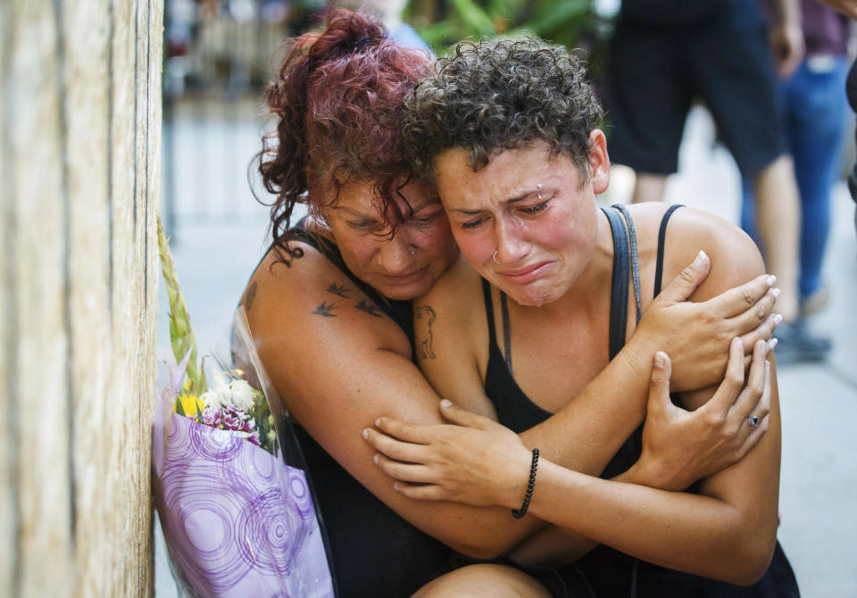 <p>Desirae Shapiro, 19, right, and her mother, Gina Shapiro, friends of 18-year-old Danforth shooting victim Reese Fallon, mourn after visiting a makeshift memorial, Monday, July 23, 2018, in Toronto, remembering the victims of the shooting on Sunday. (Photo: Mark Blinch/The Canadian Press via AP) </p>