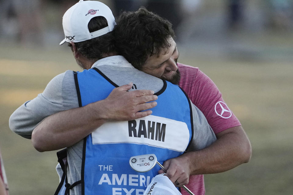 Jon Rahm, right, hugs his caddie after winning the American Express golf tournament on the Pete Dye Stadium Course at PGA West Sunday, Jan. 22, 2023, in La Quinta, Calif. (AP Photo/Mark J. Terrill)