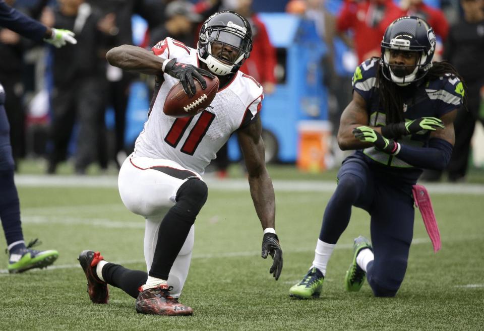 FILE - In this Oct. 16, 2016, file photo, Atlanta Falcons wide receiver Julio Jones (11) reacts after Seattle Seahawks cornerback Richard Sherman, right, broke up a pass intended for him in the second half of an NFL football game, in Seattle. Jones and the Falcons get another shot at Seattle in Saturday's divisional round playoff game. (AP Photo/Elaine Thompson, File)