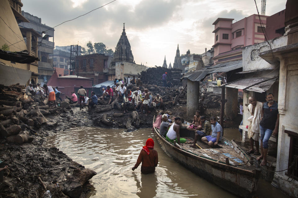 Hindu mourners wait for the cremation of their loved ones at the flooded Manikarnika Ghat, one of the oldest and most sacred places for Hindus to be cremated, on the banks of river Ganges in Varanasi, India, Tuesday, Oct. 22, 2019. As the mighty Ganges River overflows following heavy monsoon rains, large parts of the Hindu holy town of Varanasi were submerged by floodwaters, forcing thousands of cremations to happen on rooftops and narrow alleyways. For millions of Hindus, Varanasi is a place of pilgrimage and anyone who dies in the city or is cremated on its ghats is believed to attain salvation and freed from the cycle of birth and death. (AP Photo/Altaf Qadri)