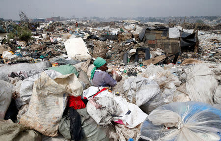 A scavenger sorts recyclable plastic materials at the Dandora dumping site on the outskirts of Nairobi, Kenya August 25, 2017. REUTERS/Thomas Mukoya