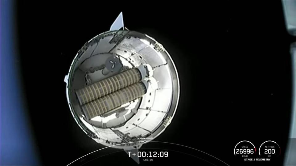 A camera on the Falcon 9's second stage captures a view of the Dragon cargo ship floating away after reaching orbit. A set of rolled-up solar array blankets is visible in the spacecraft's unpressurized trunk section. / Credit: NASA TV