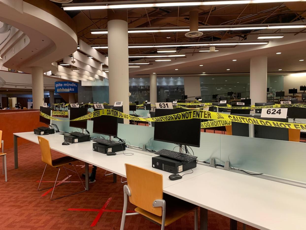 Computers blocked off with tape at a Toronto Public Library branch earlier this month. The library says access to some services, including its website and public computers, won't begin to be restored until the new year. (Haydn Watters/CBC - image credit)
