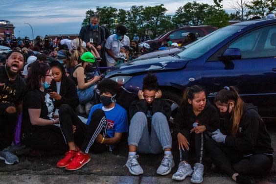 The Independent’s Andrew Buncombe, in blue mask, interviews protesters as they are arrested in Minneapolis (Getty)